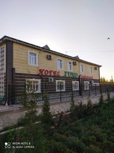 a building with a fence in front of it at Humo Hotel and Restaurant in Bŭston
