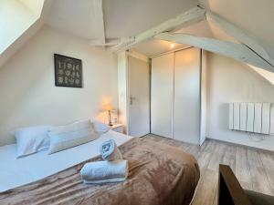 a bedroom with a large bed with two towels on it at Le Douare, Proche centre-ville, Parking in Morestel