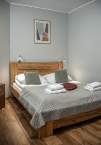 1 dormitorio con 1 cama grande de madera y 2 almohadas en B&b flats, en Wroclaw