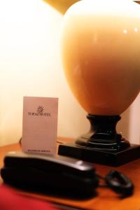 a lamp on a table with a card on it at Topaz Hotel in St Paul's Bay