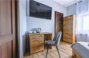 a bedroom with a chair and a desk with a television at Rynek aparts in Wrocław