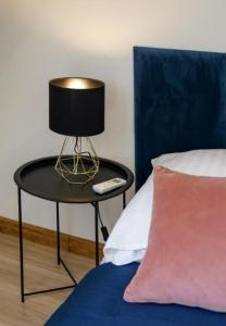 a table with a lamp on it next to a bed at Rynek aparts in Wrocław