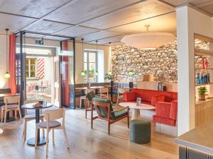 a restaurant with tables and chairs and a bar at KORNHAUS Boutique Hotel in Murten