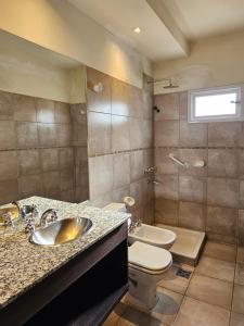 a bathroom with a sink and a toilet at Hotel Riviera in Córdoba