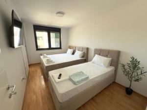 a small room with two beds and a window at Mint House in Niš