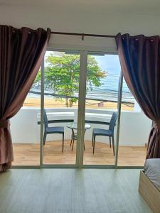 ein Esszimmer mit Blick auf das Meer in der Unterkunft Beach front B3 Marie Guest house in Jomtien Beach