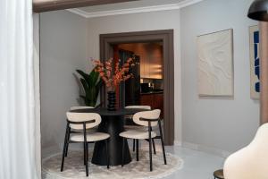 a dining room with a black table and chairs at RJV Apartments, Meanwood Ibex Hill, Lusaka in Lusaka
