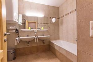 a bathroom with two sinks and a bath tub at Haus Bergland in Bad Kleinkirchheim