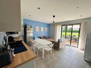 a kitchen and dining room with a table and chairs at Chez M&S - Maison 3 chambres et 3 salles de bain in Bressolles