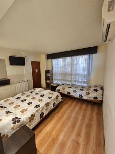 a bedroom with two beds and a large window at Hotel Riviera in Córdoba