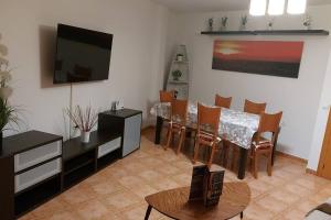 a living room with a dining table and a television at El Nido de Candeleda in Candeleda