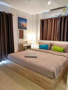a bedroom with a large bed with green and blue pillows at Beach front B3 Marie Guest house in Jomtien Beach