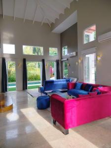 a large living room with a red couch and blue chairs at LaGita Carita Beach Villa 2 in Carita +19 photos
