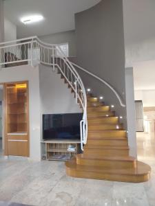 a spiral staircase in a living room with a tv at LaGita Carita Beach Villa 2 in Carita