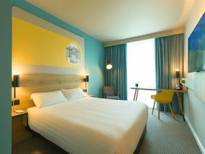 ウォリントンにあるB&B HOTEL Warringtonの大きなベッドと机があるホテルの部屋