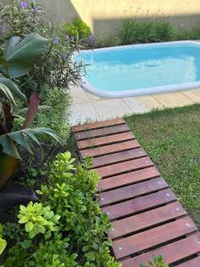 een achtertuin met een zwembad en een houten loopbrug bij Casita de Barrio in Lobos