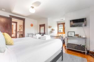 een slaapkamer met een groot wit bed en een tv bij Boscobel Bungalow in Nashville