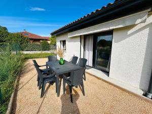 a black table and chairs on a patio at Chez M&S - Maison 3 chambres et 3 salles de bain in Bressolles