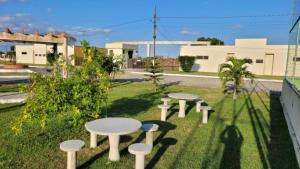 a row of white tables and stools on the grass at Monte das cerejeiras - Bananeiras in Bananeiras