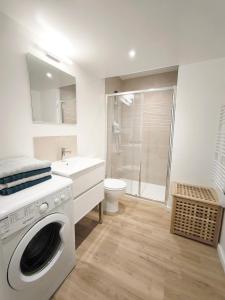 Un baño con lavadora y un inodoro. en Bleu océan cosy avec accès autonome, en Villejuif