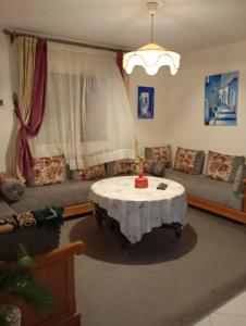 una sala de estar con una mesa y un sofá en Samoura perla, en Agadir