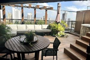 a patio with a table and chairs and a couch at Cobertura Duplex, com 3 Suítes, Piscina e Área Gourmet in Belém