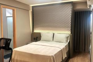 a small bedroom with a bed with white sheets at Cobertura Duplex, com 3 Suítes, Piscina e Área Gourmet in Belém