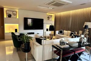 a living room with a couch and a tv at Cobertura Duplex, com 3 Suítes, Piscina e Área Gourmet in Belém
