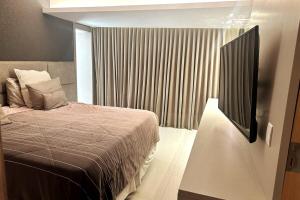 a bedroom with a bed and a window with avertisement at Cobertura Duplex, com 3 Suítes, Piscina e Área Gourmet in Belém