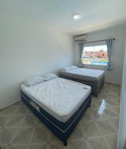 two beds in a small room with a window at Cacao's Guaibim Residence in Valença +45 photos