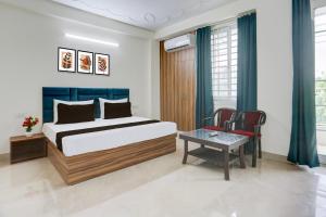 een slaapkamer met een bed, een tafel en stoelen bij Hotel O THE AEROSITY in New Delhi