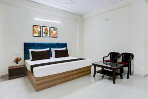 een slaapkamer met een bed, een tafel en stoelen bij Hotel O THE AEROSITY in New Delhi