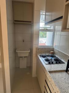 een keuken met een fornuis en een spoelbak bij Studio V Ininga - 610 in Teresina