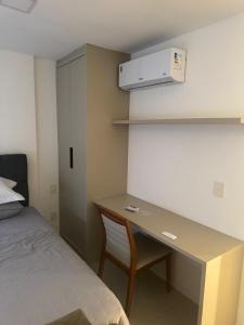een kamer met een bureau, een bed en een bedrok bij Studio V Ininga - 610 in Teresina