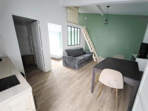 una sala de estar con una mesa y un sofá en Bleu océan cosy avec accès autonome, en Villejuif