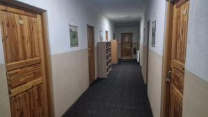 a hallway with wooden doors and a hallway with stairs at Chaty pod Gýmešom - turistická ubytovňa in Nitra