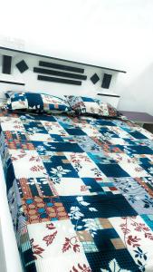 una cama con una colcha de colores encima en Jagadeeshwara comforts kalasa, en Kalasa