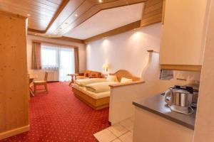 a living room with a bed and a kitchen at Haus Bergland in Bad Kleinkirchheim