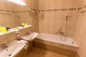 a bathroom with a tub and a sink and a bath tub at Haus Bergland in Bad Kleinkirchheim