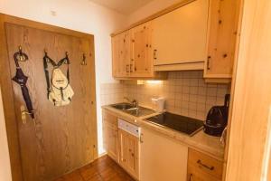 a kitchen with a sink and a wooden door at Haus Bergland in Bad Kleinkirchheim +16 photos
