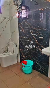 un baño con inodoro y lavabo en Jagadeeshwara comforts kalasa, en Kalasa