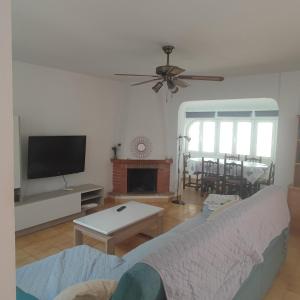a living room with a couch and a flat screen tv at Casa costacabana in Almería