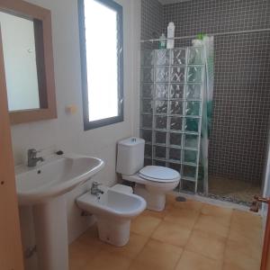 a bathroom with a sink and a toilet and a shower at Casa costacabana in Almería +1 photo