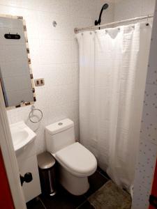 a bathroom with a white toilet and a sink at La Casa del Pueblo Hostal in San Pedro de Atacama