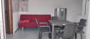 a red couch in a room with a table and chairs at Apartamento independiente amoblado mompox dos aires acondicionado in Mompos