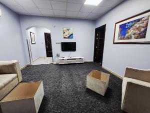 a living room with a couch and a tv at شقق العصر الماسي للشقق المفروشة - Al Asr almasi Suite Apartments in Al Madinah
