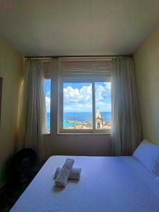 a bedroom with a bed and a large window at Melhor Localização do Centro Histórico de Salvador in Salvador