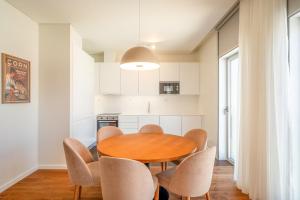 Una cocina y un comedor con mesa y sillas de madera. en GuestReady - Republic Apartments, en Lisboa