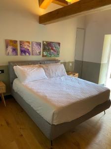 a bed in a bedroom with paintings on the wall at B e B Villa Livia in Rolo +6 photos