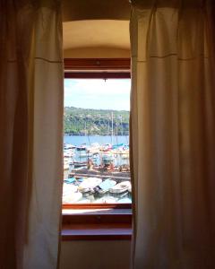a window with a view of a marina with boats at Il Palazzo in Volosko